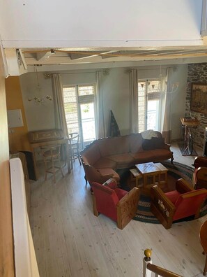 A living room with a sofa, chairs, a table, and a bicycle.