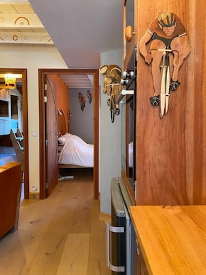 A narrow hallway with a bed, wooden walls, and a bicycle mounted on the wall.