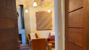A hallway leading to a living area with a sofa, a coffee table, and a wall-mounted artwork. - Jasmine, pretty hat, on a bicycle (Bagnères-de-Luchon)