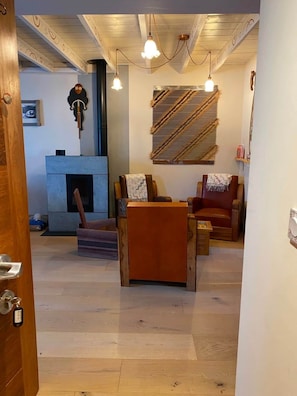 A room with a fireplace, wooden furniture, and hanging light fixtures.