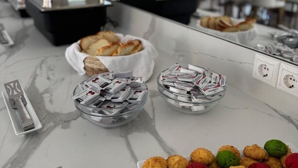 A marble countertop with various food items and a plate of colorful pastries. - Llia hotel  (Kobuleti)