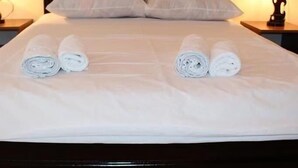 A neatly made bed with two rolled towels placed on the bed. - Llia hotel  (Kobuleti)
