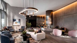 Un'area lounge moderna con divani, un tavolino da caffè e un'ampia lampada circolare.