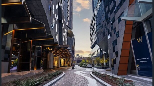 Una strada cittadina moderna con marciapiede lastricato, edifici su entrambi i lati e cielo sereno.