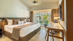 A hotel room with a large bed, a dining table, and a balcony with outdoor seating.