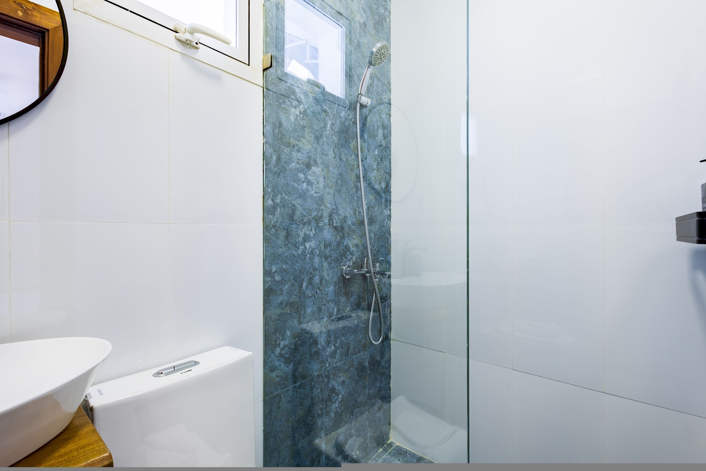 A bathroom with a shower, a toilet, and a sink.