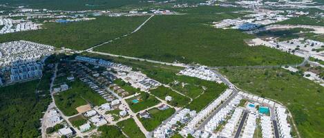 Vista aérea de una zona residencial con varios complejos de apartamentos, carreteras y espacios verdes.
