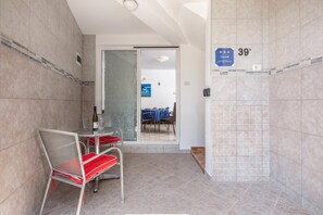 A hotel room with a dining area, a shower, and a view of the outside. - Peaceful Retreat Apartments With Terrace (Marcana)