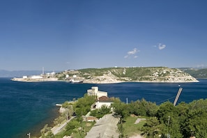 Une vue sur la côte, avec une petite île, un phare et un bâtiment doté d’un toit en pente.