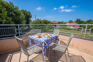 A balcony with a table set for breakfast, chairs, and a railing. - Peaceful Retreat Apartments With Terrace (Marcana)
