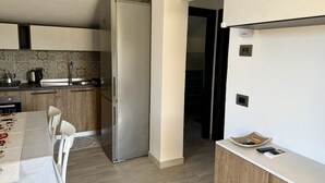 Una cocina moderna con refrigerador de acero inoxidable, armarios de madera y salpicadero de azulejos.
