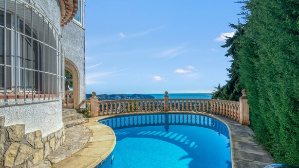 A swimming pool with a stone deck, a stone wall, and a view of the ocean. - Villa 'Gaga Moraira' with Sea Views, Wi-Fi, and Air Conditioning (Teulada)