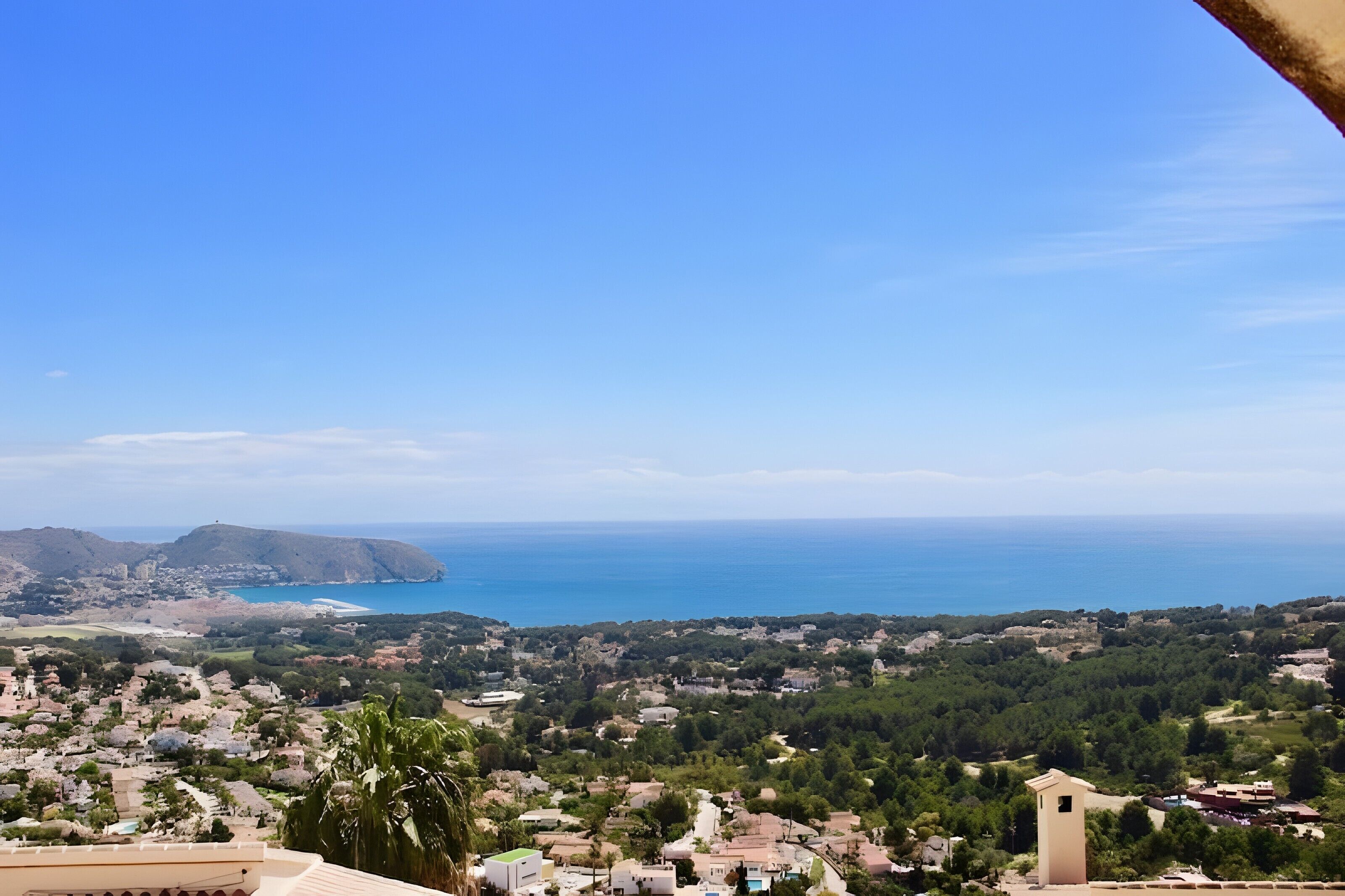 Une ville côtière offrant une vue sur la mer, des bâtiments et une tour.