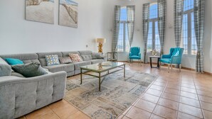 A spacious living room with a grey sofa, a glass coffee table, and two blue armchairs. - Villa 'Pinosol Con Vista Al Mar' with Sea View, Wi-Fi and Air Conditioning (Jávea)