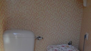 A bathroom with a toilet, a bidet, and a sink.