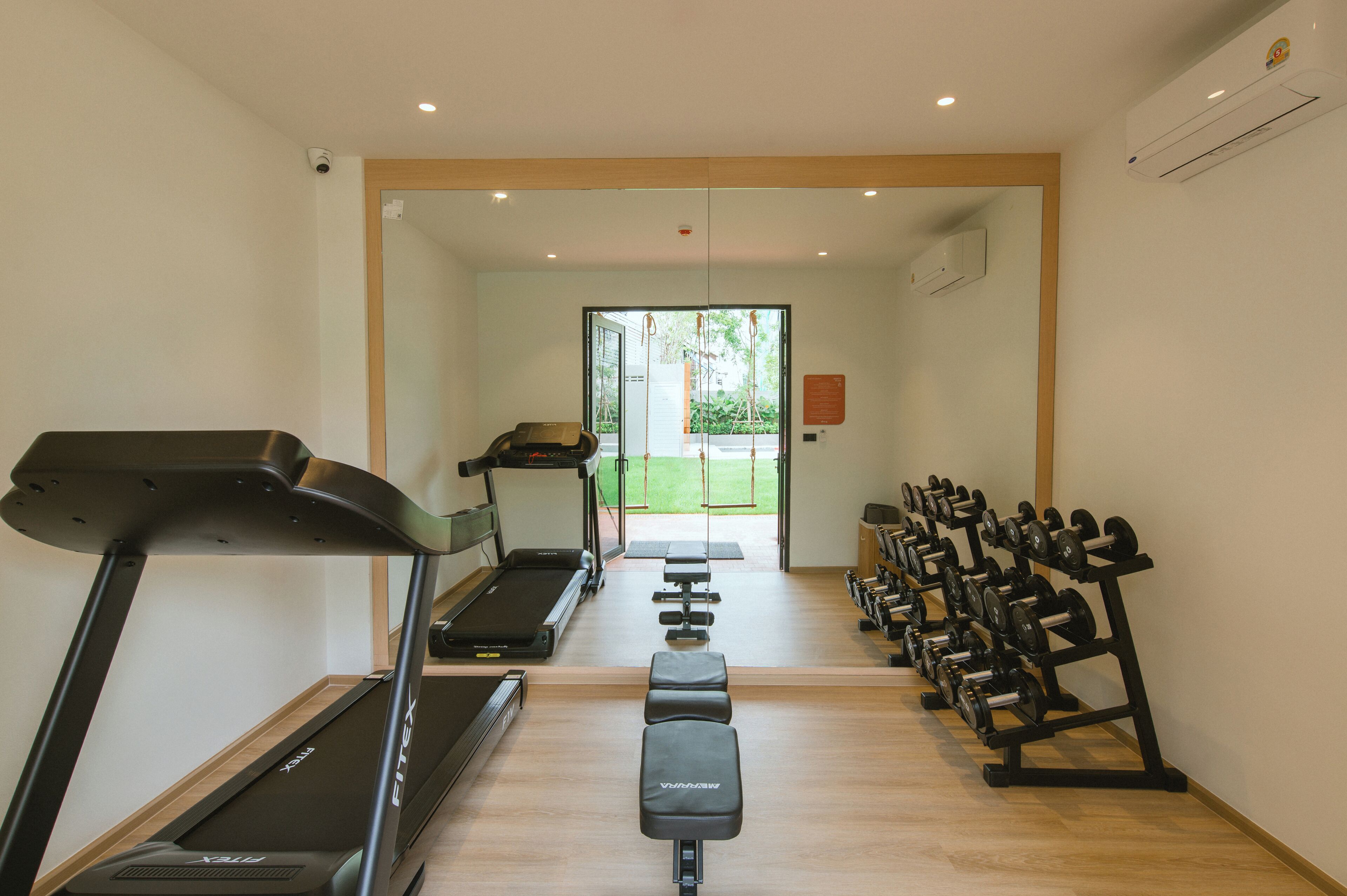 A gym with treadmills, a stationary bike, and a bench.
