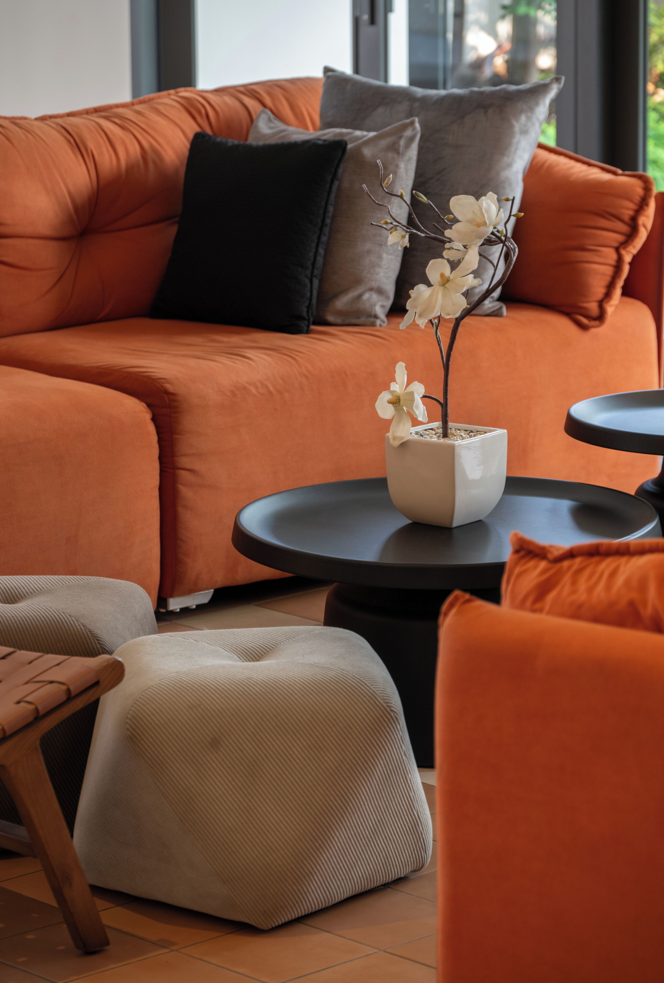 A modern living room with a sectional sofa, a round coffee table, and a small potted plant.