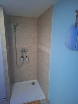 Chuveiro, toalhas de banho, sabonete, shampoo