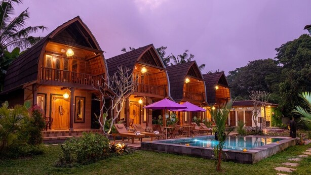 A row of wooden villas with balconies, a swimming pool, and outdoor seating. - Yama VIlla & SPA Ubud (Payangan)