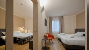 A hotel room with two single beds, a small table with a vase, and a chair. - Zenit Park Hotel (Rivalta di Torino)