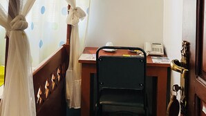 A room with a bed covered by a white canopy, a desk with a chair, a telephone, and a green trash bin. - parachichi house Bed and Breakfast  (Arusha)