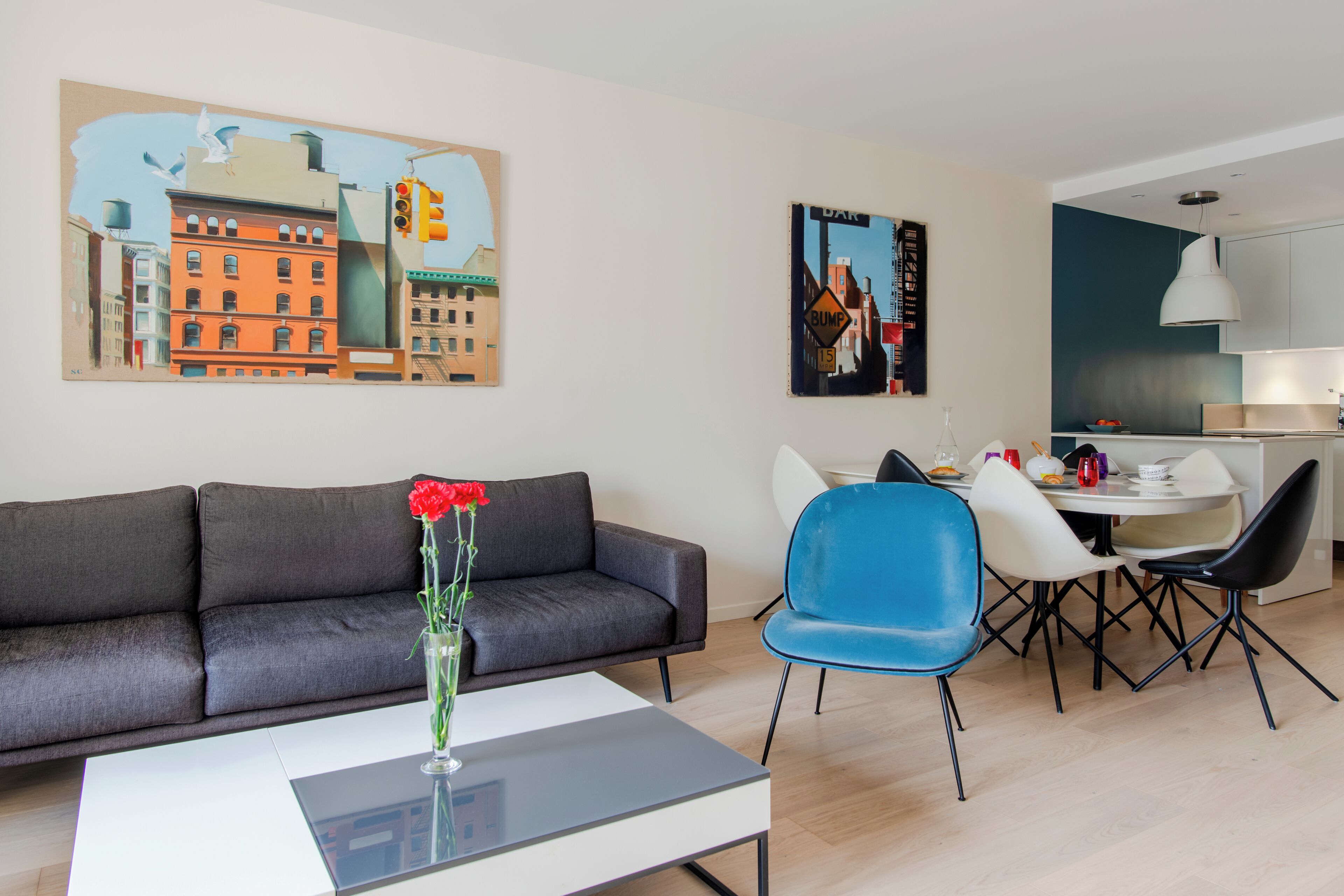 Una sala de estar moderna con sofá, una mesa de centro y un comedor con sillas y una mesa.