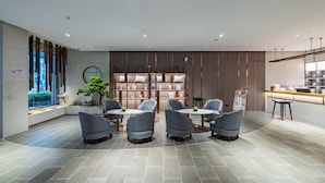 A modern hotel lobby with a seating area, a reception desk, and a large window overlooking a cityscape. - Palace Hotel Shenzhen Luohukou (Shenzhen)