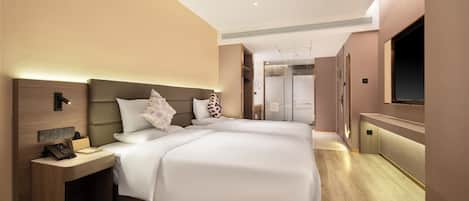 Una habitación de hotel moderna con una cama grande, mesitas de noche, televisión y zona de ducha.