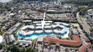An aerial view of a resort with a central swimming pool surrounded by hotel buildings, roads, and greenery. - Pacific Blue Unit 175 Dual Swim Up B (Salamander Bay)