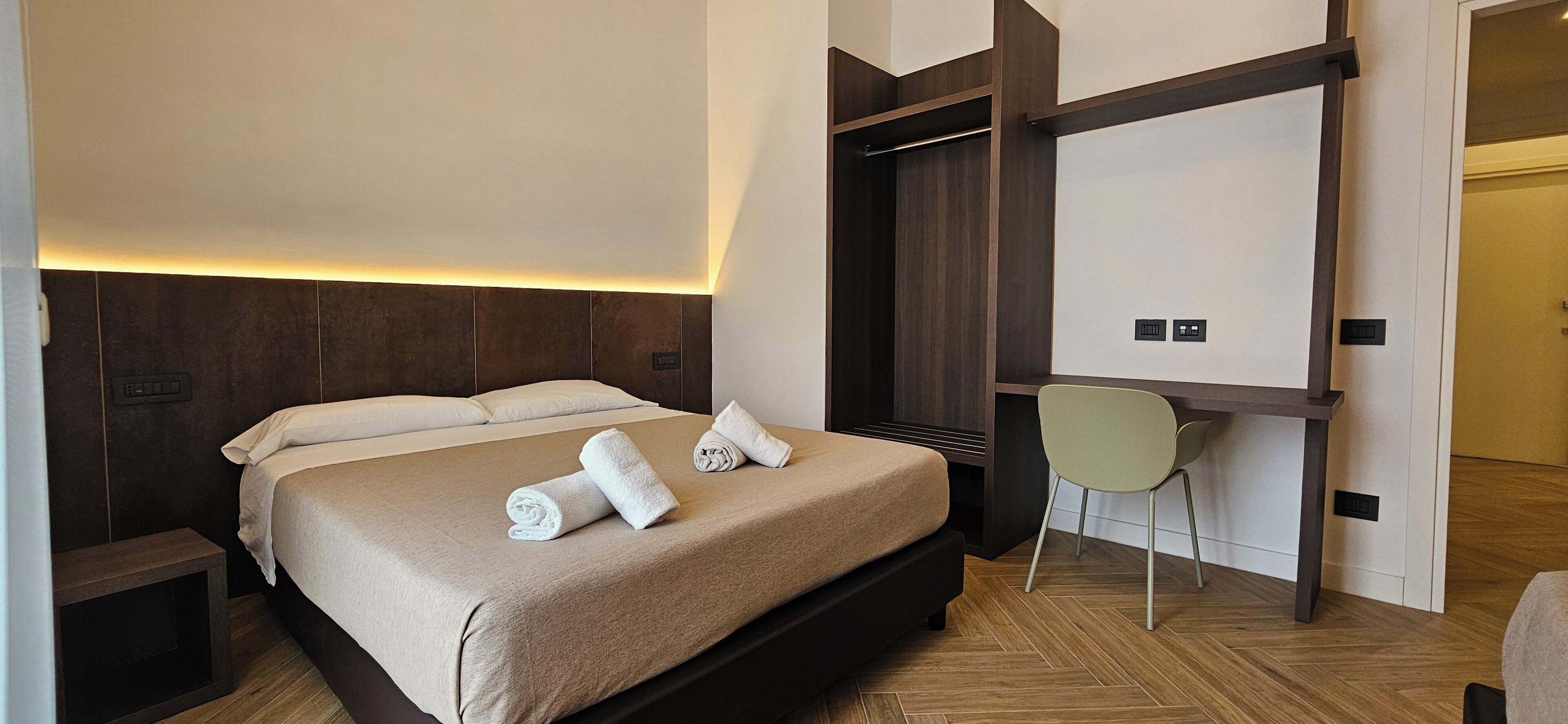 Una habitación de hotel con una cama, un escritorio y una silla.
