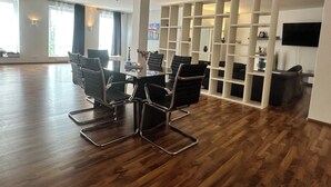 A spacious living area with a dining table, chairs, and a TV mounted on the wall. - Luxury loft in Bayreuth Central&Exclusiv (Bayreuth)