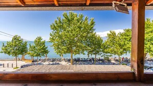 A wooden deck with a view of a beach and mountains. - Shiroka Stays 2 in Shkod r (Shkodër)