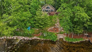 A house surrounded by lush greenery and a small pond. - Private beach house in charming Pound on a clear, sandy full rec lake (Pound)