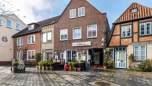 Een klassiek Europees gebouw met een bakstenen gevel, meerdere ramen en een bord dat een restaurant aangeeft.