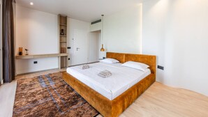 Un dormitorio moderno con una cama grande, un armario empotrado, una mesita de noche y una lámpara de noche.
