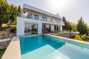 A modern two-story house with a swimming pool, outdoor furniture, and a stone retaining wall. - Lake Whisper Villa Pool Amazing Views (Shkodër)