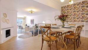 A dining area with a white table, wooden chairs, and a patterned wall. - Stunning Apartment With City Views. San Pablo (Seville)