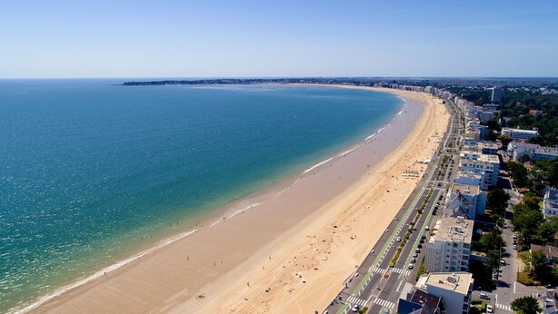 An aerial view of a coastal city with a wide sandy beach, a clear blue sea, and a row of modern buildings along the shore. - House w/ garden & terrace – 6 adults/2 kids (La Baule-Escoublac)