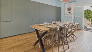 A dining area with a wooden table set for six, grey cabinets, and a view of the outdoors. - House w/ garden & terrace – 6 adults/2 kids (La Baule-Escoublac)