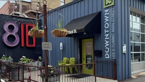 A building with a sign reading "Downtown Lee's Summit Main Street" and a large number '810' on the facade. - Modern Style_Sleeps 8_Walkable Area_Fenced Yard (Lee's Summit)