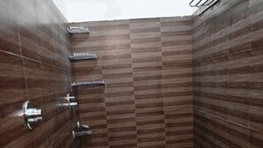 A bathroom with a toilet, a shower, and a hand dryer.