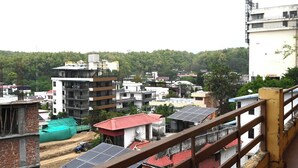A residential area with multi-story buildings, some with solar panels, and a construction site.