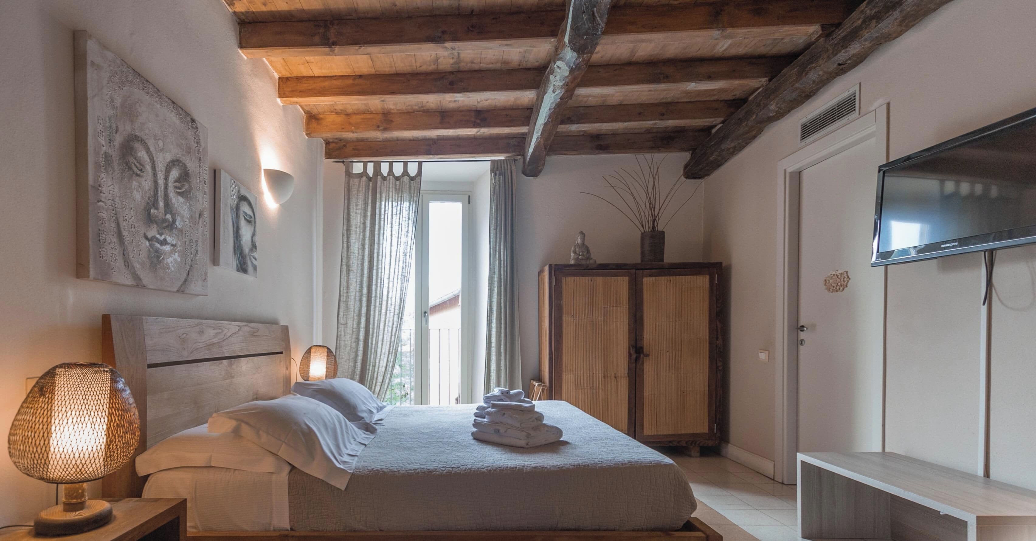 Un dormitorio con cama, televisor, armario y una obra de arte en la pared.