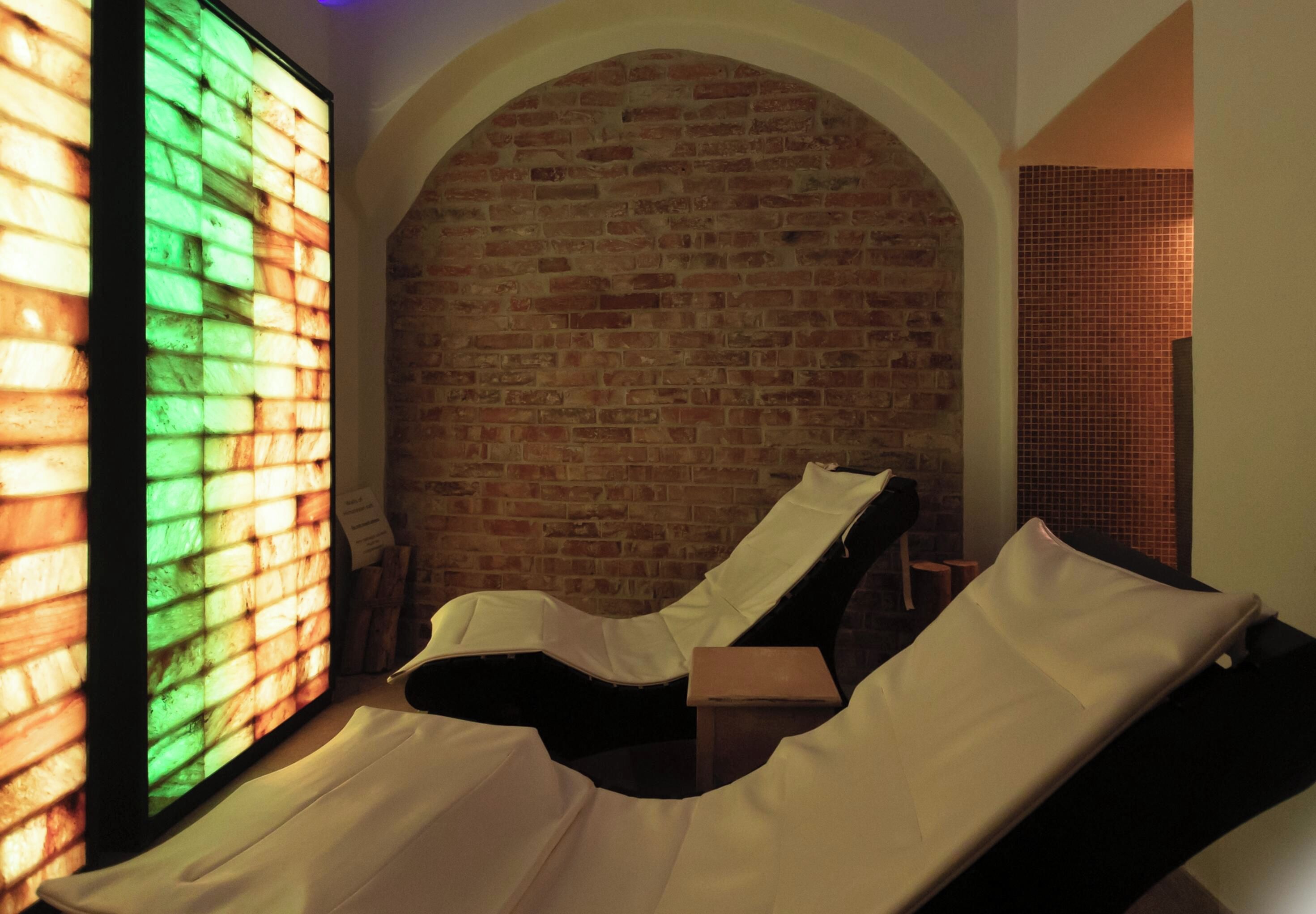 Una habitación con pared de ladrillo, una ventana con vitrales y un sillón reclinable.