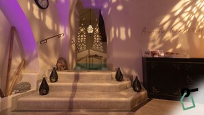 Una escalera con una estatua de Buda, un reloj de pared y un farol decorativo.