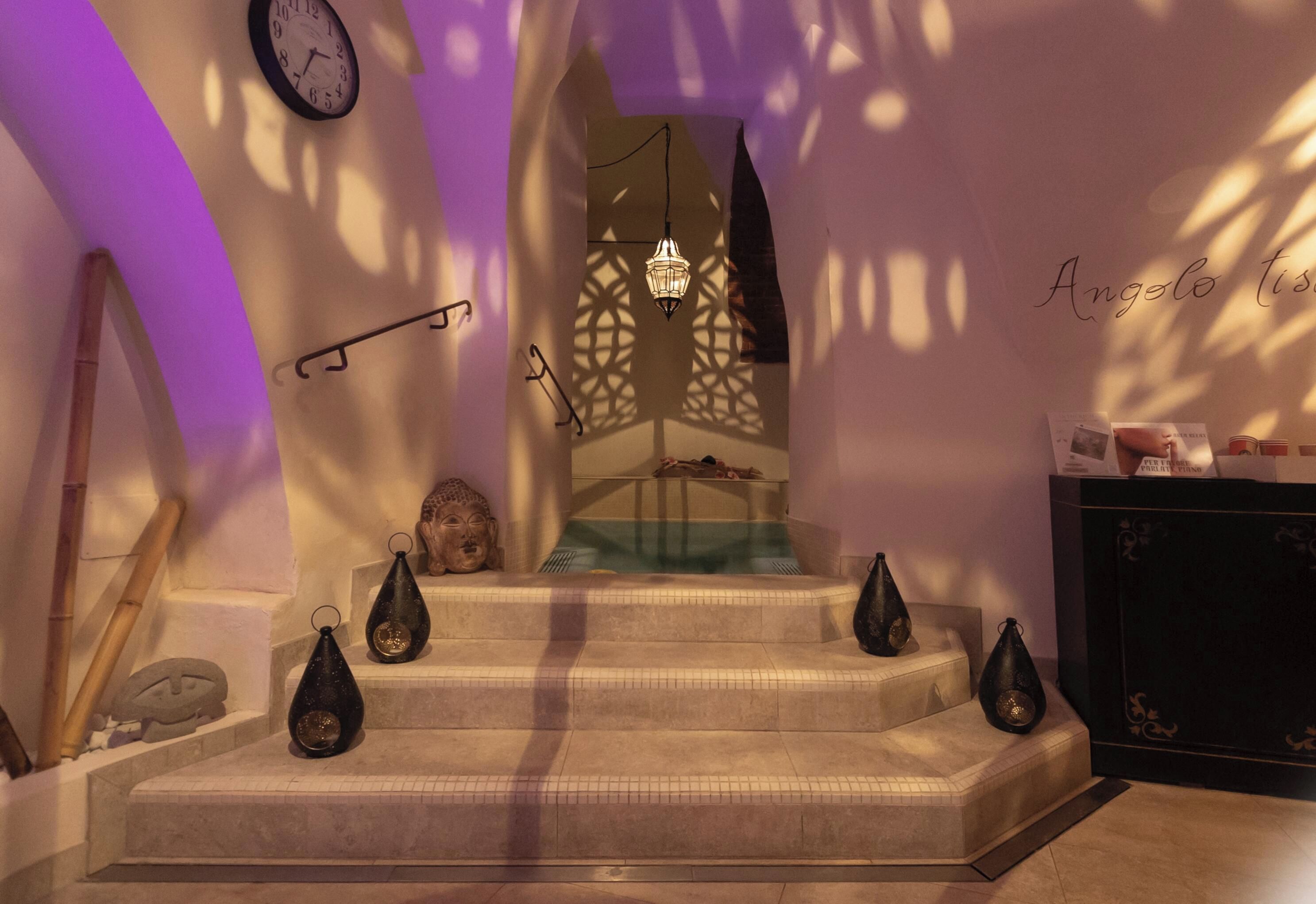 Una escalera con una estatua de Buda, un reloj de pared y un farol decorativo.