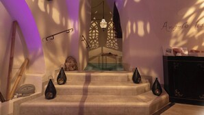 A staircase with decorative elements, a clock, and a wall with a partial text.