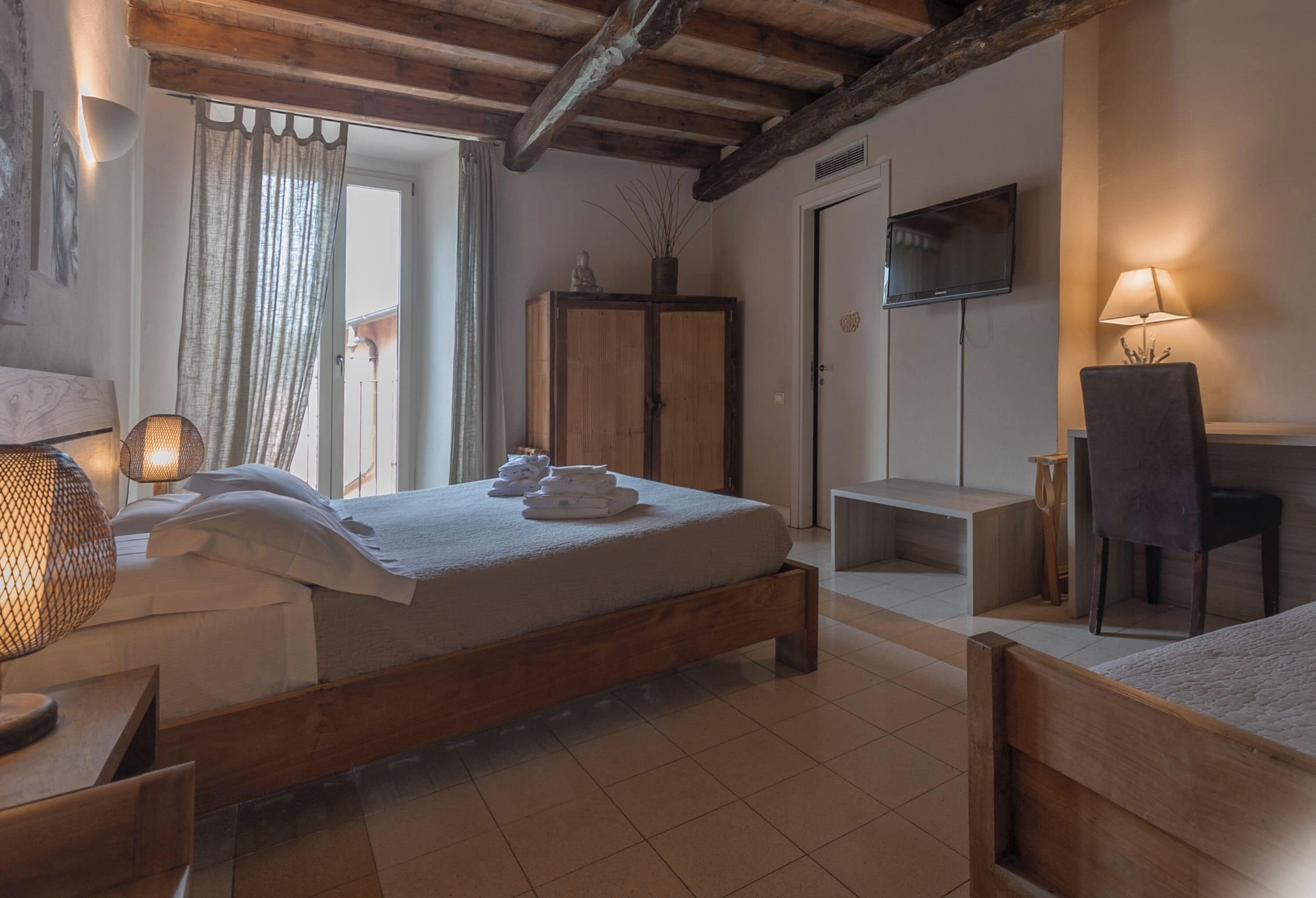 Une chambre comprenant un lit, un bureau, une chaise, une armoire et un téléviseur.