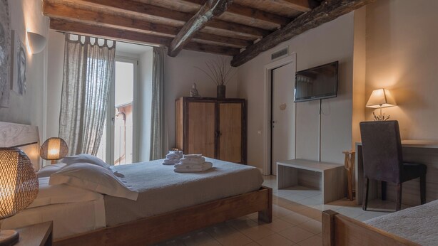 Een kamer met een bed, bureau, stoel, kledingkast en een televisie.