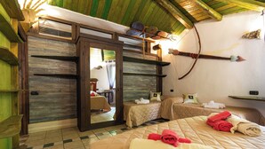 A room with a large bed, two smaller beds, wooden walls, a mirror, and a ceiling with wooden beams. - Flight Country Resort (Castel dell'Aquila)
